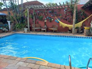 隆德里纳Alpha Hospedaria & Hostel的后院的游泳池,有红色的墙壁