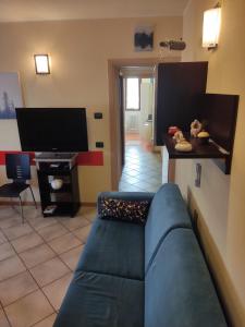 BaganzolaResidenza tra Parma e Fiere的客厅配有蓝色的沙发和电视