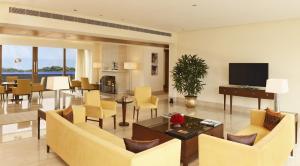 古尔冈古尔冈奥博罗伊酒店的客厅配有黄色椅子和电视