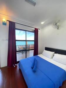 停泊岛Perhentian Nemo Chalet的一间享有海景的卧室,配有一张蓝色的床