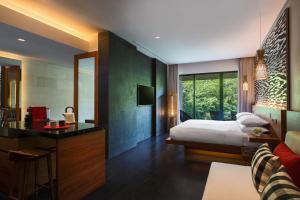 乌鲁瓦图巴厘岛乌鲁瓦图万丽度假酒店及Spa的一间卧室配有一张床和一张书桌,另一间卧室配有一张桌子。