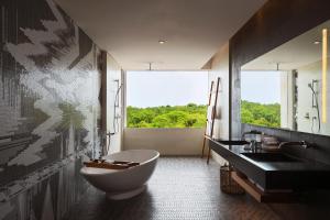 乌鲁瓦图巴厘岛乌鲁瓦图万丽度假酒店及Spa的带浴缸、水槽和窗户的浴室