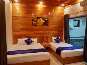 宁平Trang an green river homestay的木墙客房的两张床