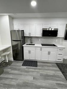 布兰普顿New Luxurious Studio Apartment的厨房配有白色橱柜和不锈钢冰箱