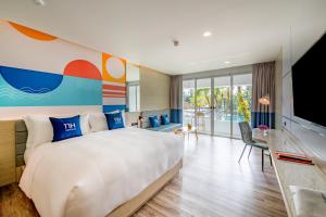 普吉镇NH Boat Lagoon Phuket Resort的酒店客房设有一张大床和一台电视。