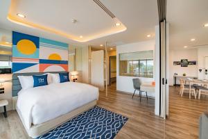 普吉镇NH Boat Lagoon Phuket Resort的一间卧室设有一张床和一间用餐室