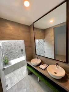 Kampung MawarChantara Cottage的一间带两个盥洗盆和大镜子的浴室
