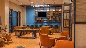 塞恩ibis Thane - An Accor Brand的一间设有桌椅和电视的等候室