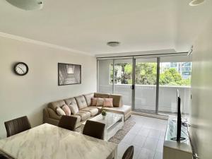 悉尼Charming One-Bed Apt in the Heart of Parramatta的客厅配有沙发和桌子