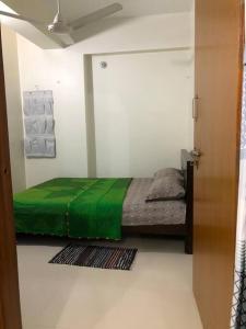 吉大港Home Away From Home的一间卧室配有一张带绿毯的床
