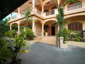 贡布Villa Kampot Cafe的一座大建筑,有楼梯和植物