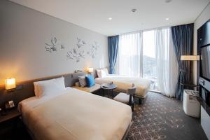 首尔首尔格拉斯丽酒店的酒店客房设有两张床和电视。