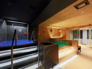 东京Rembrandt Cabin & Spa Shimbashi - Caters to Men的带楼梯的客房内的按摩浴缸