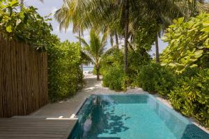 芭环礁Avani Plus Fares Maldives Resort - 50 percent off on Seaplane transfer for minimum 7-nightstay till 22 Dec 2024的棕榈树度假村前的游泳池