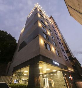 釜山Maron Hotel Nampo的一座高大的建筑,上面有灯