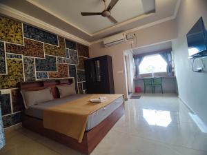 瓦加蒙Green Palace Resort的卧室配有一张床和瓷砖墙