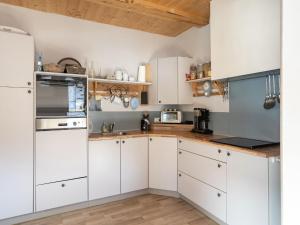 兰格尔斯道夫Chalet in Rangersdorf in Carinthia near ski area的厨房铺有木地板,配有白色橱柜。