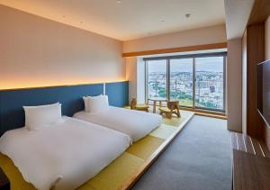 MinatogawaHOTEL AlaCOOJU OKINAWA的酒店客房设有两张床和大窗户。