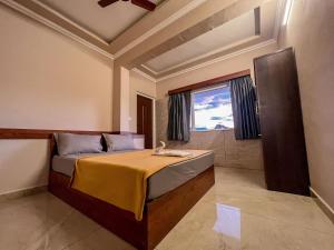 瓦加蒙Green Palace Resort的一间卧室设有一张床和一个大窗户