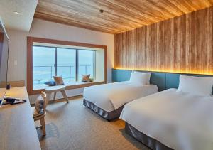 MinatogawaHOTEL AlaCOOJU OKINAWA的酒店客房设有两张床和窗户。