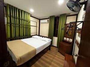 瓜拉丁加奴Inap Nekmi Kuala Terengganu With Pool的一间卧室配有床和绿色窗帘