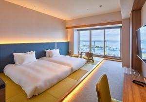 MinatogawaHOTEL AlaCOOJU OKINAWA的酒店客房设有一张床,享有海景。