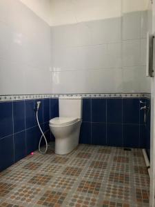 茂物Yayah Hostel的浴室设有蓝色和白色的墙壁,配有卫生间