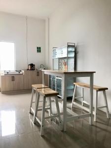 茂物Yayah Hostel的厨房配有一张桌子和两张凳子