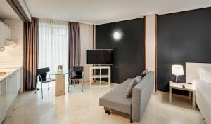 马德里Sercotel Togumar的酒店客房配有床、沙发和电视。