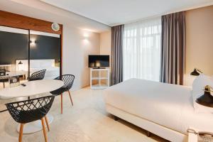 马德里Sercotel Togumar的酒店客房带一张床、一张桌子和椅子
