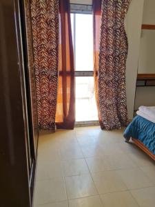 沙姆沙伊赫basic 2 bedroom apartment的客房设有窗帘和瓷砖地板。
