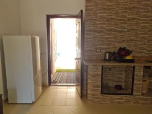 沙姆沙伊赫basic 2 bedroom apartment的厨房配有冰箱和砖墙