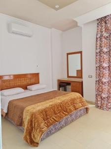 沙姆沙伊赫basic 2 bedroom apartment的一间卧室配有一张床、一张书桌和一面镜子