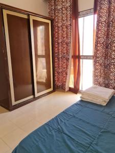 沙姆沙伊赫basic 2 bedroom apartment的一间卧室设有蓝色的床和窗户。