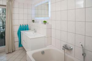 施特拉尔松德Haus mit 110qm und Garten 150m zum Wasser的白色的浴室设有浴缸和水槽。