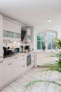 施特拉尔松德Haus mit 110qm und Garten 150m zum Wasser的白色的厨房配有白色橱柜和窗户