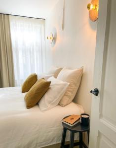 奥德纳尔德La Porte Rouge - The Red Door的卧室配有带白色枕头的床和窗户。