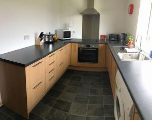 CreagorryTraditional Croft house的厨房配有黑色台面和水槽