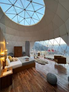 马拉里GLAMPING CLUB的一间卧室设有一张床和一个大型玻璃天花板