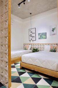 岘港URI HOUSE, 1-2 BR tourism apt, 5' walk Dragon Bridge的卧室内的两张床,铺有 ⁇ 木地板