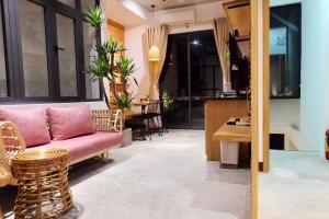 岘港URI HOUSE, 1-2 BR tourism apt, 5' walk Dragon Bridge的客厅配有粉红色的沙发和桌子