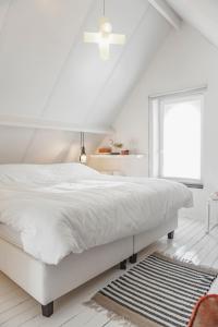 迪克斯梅德朱丽叶特度假屋的白色的卧室设有白色的床和窗户。