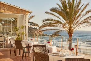 帕格拉Secrets Mallorca Villamil Resort & Spa - Adults Only (+18)的一间带桌椅的海景餐厅