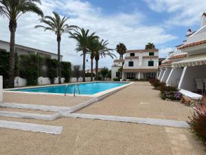 福尔内利斯MISTRAL 10 by SOM Menorca的棕榈树建筑前的游泳池