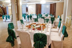 巴甫洛达尔Nurtau的宴会厅配有白色桌子和绿色椅子