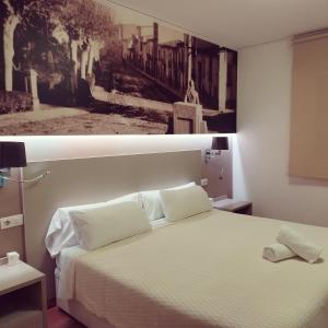 比亚雷亚尔Hello Villarreal Suites的卧室两张照片,配有一张床