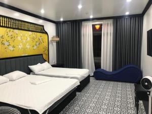海防Song Kim Hotel的一间卧室配有两张床和一张蓝色椅子