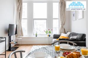 伦敦Charming 1 Bed Apt in Kensington - Free London Tour Included By City Apartments UK Short Lets Serviced Accommodation的客厅配有餐桌和食物