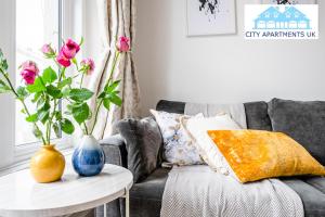 伦敦Charming 1 Bed Apt in Kensington - Free London Tour Included By City Apartments UK Short Lets Serviced Accommodation的客厅配有沙发和带花瓶的桌子