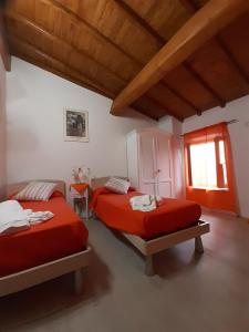 博马尔佐B&B Il Grifo的一间卧室设有两张床和窗户。